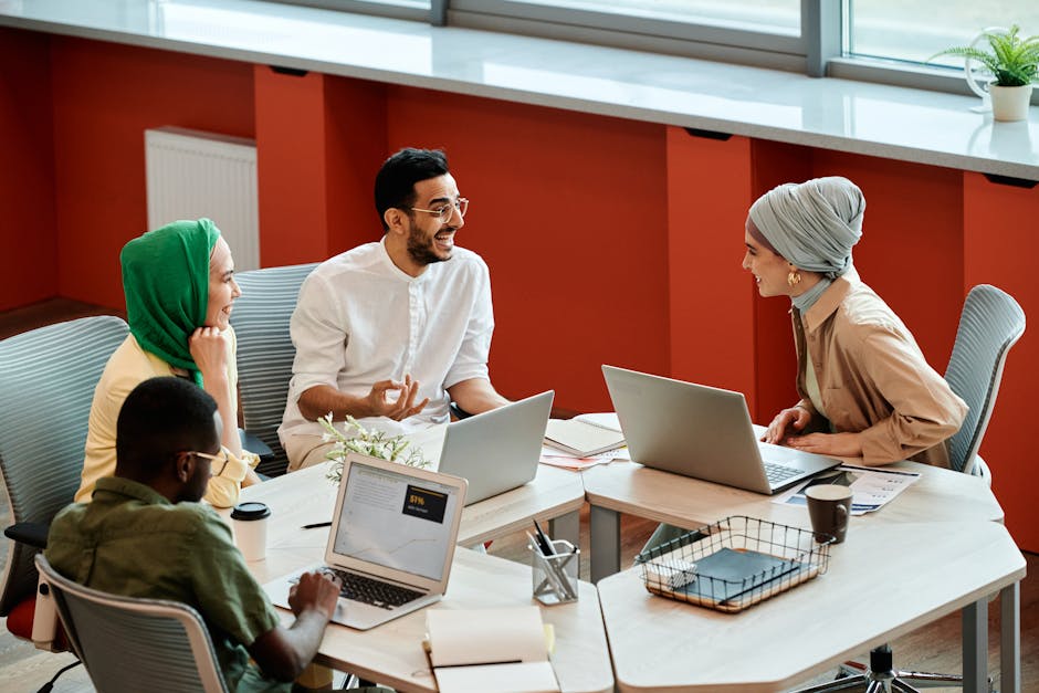 Diverse team collaborating in a modern office with security awareness posters visible in the background