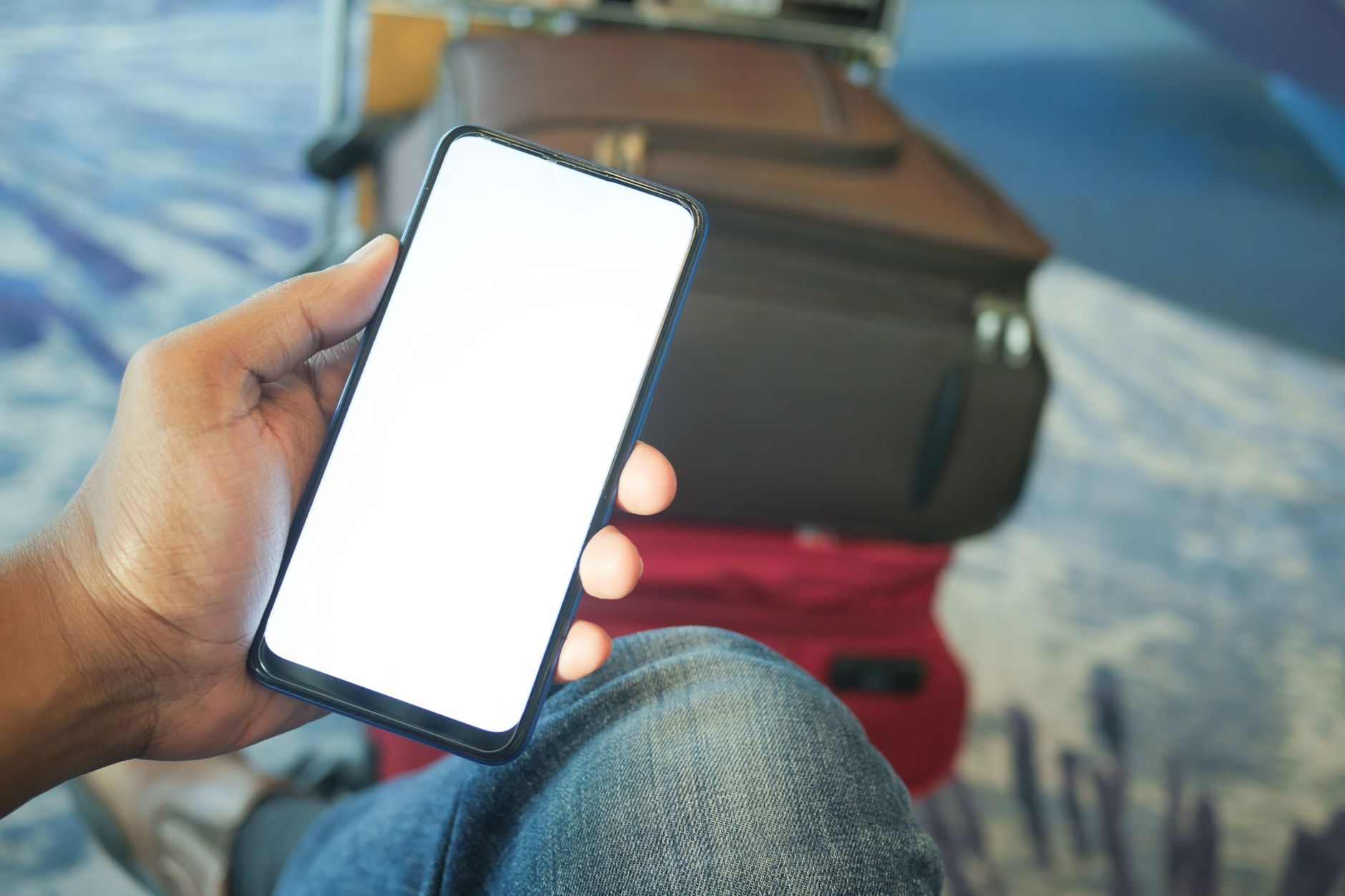 Traveler checking a booking confirmation on a smartphone at an airport