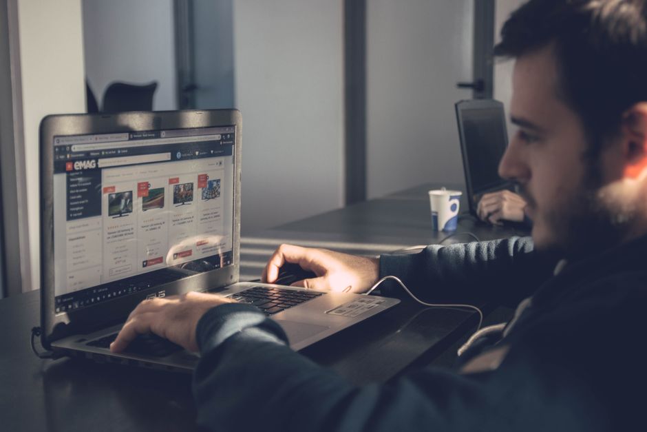 Employee searching for a software download on a laptop in an office