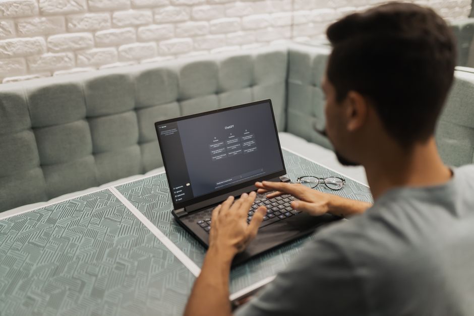 Employee entering text into an AI chatbot on a laptop at work