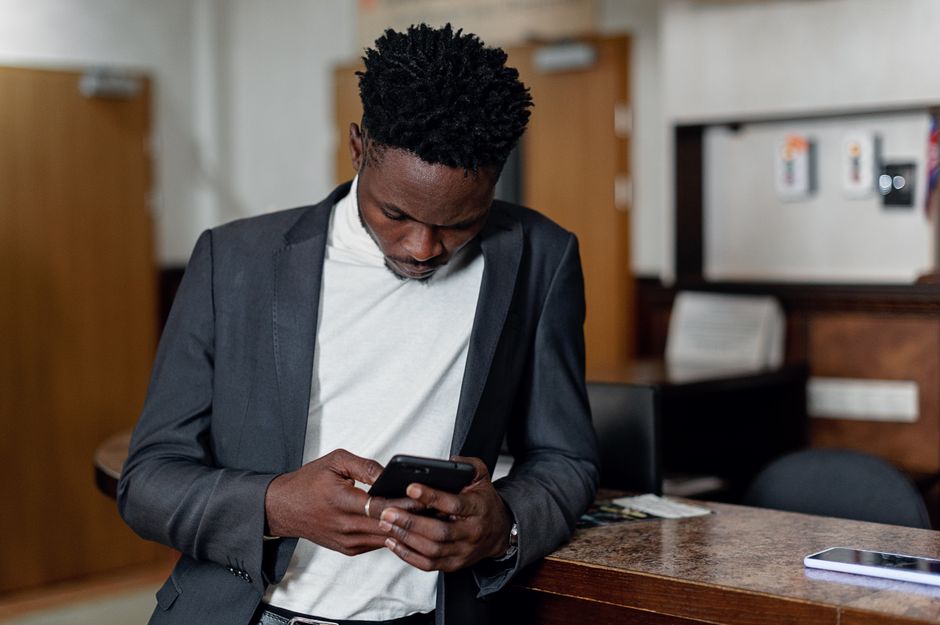 An employee reading an urgent text message on a smartphone at work