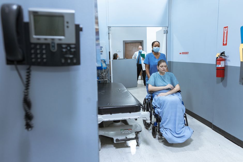 Clinical staff working in a hospital corridor where IT system outages directly affect patient care