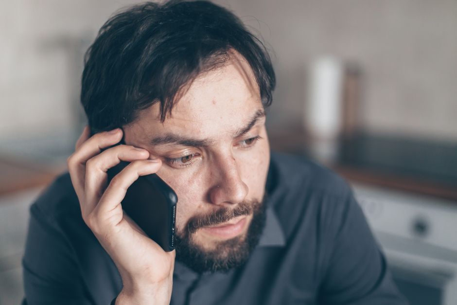 Employee looking at a concerning email on their phone in a calm office setting