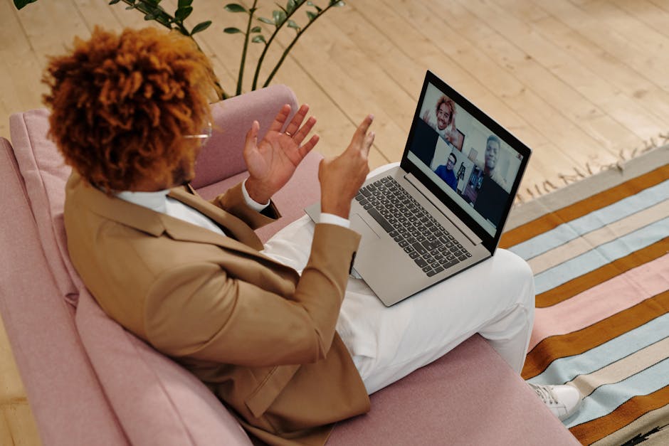 Office worker on a laptop video call reviewing a chat message in a collaboration app