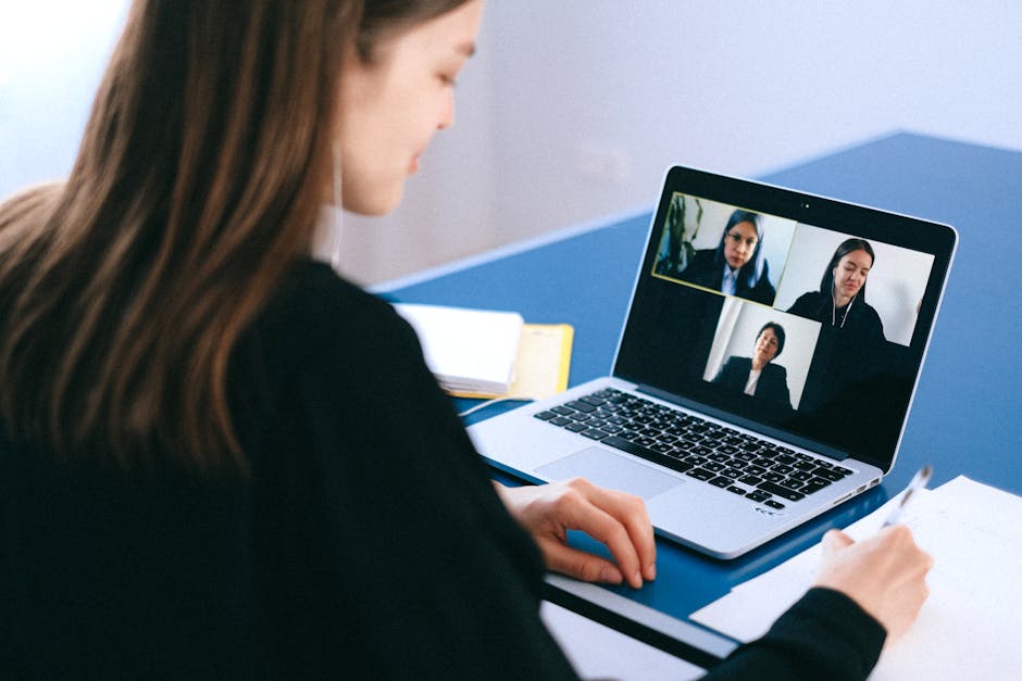 A hiring manager conducting a remote video interview on a laptop