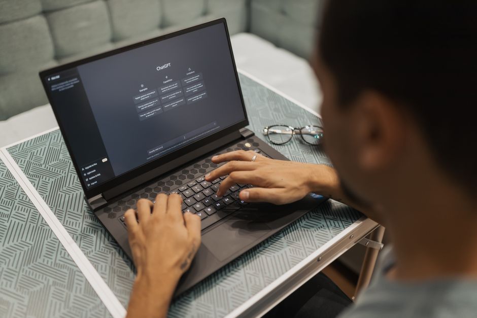 A professional using an AI assistant on a laptop in an office