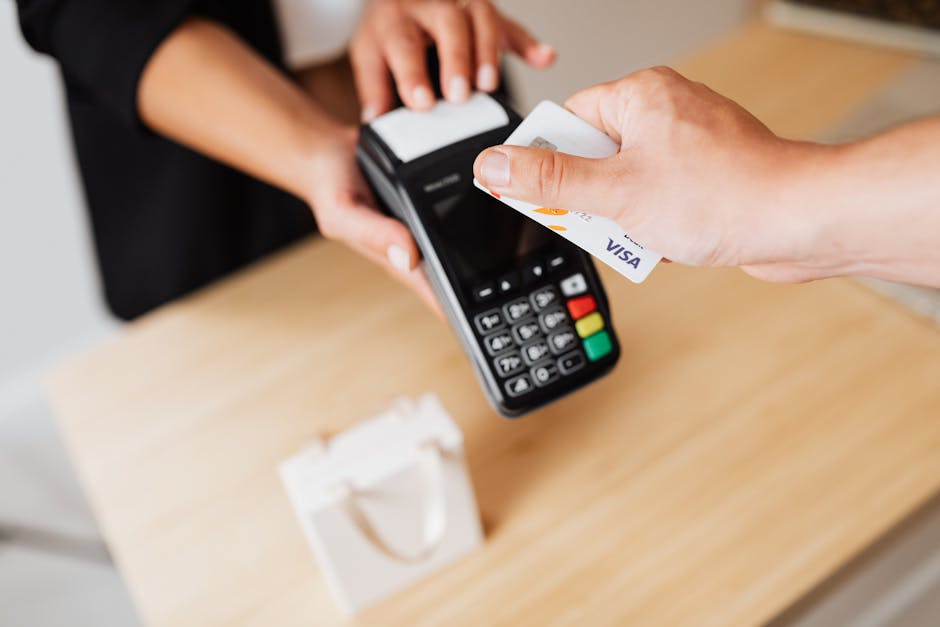 Employee processing a card payment at a point-of-sale terminal in a retail environment