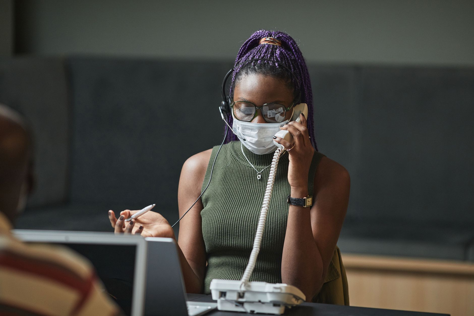 Employee receiving an unexpected phone call at an office workstation
