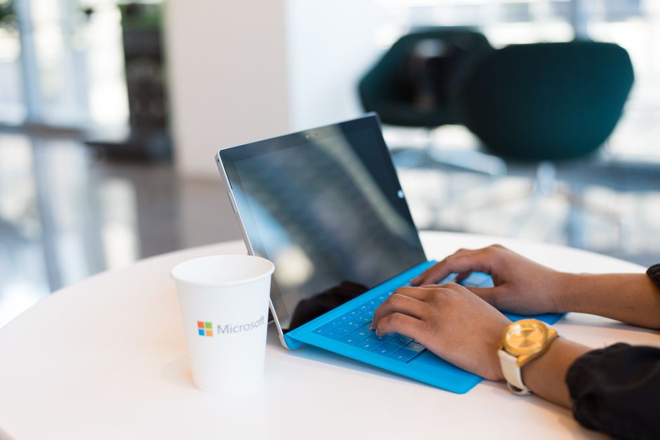 Employee entering a login code on a laptop at an office desk