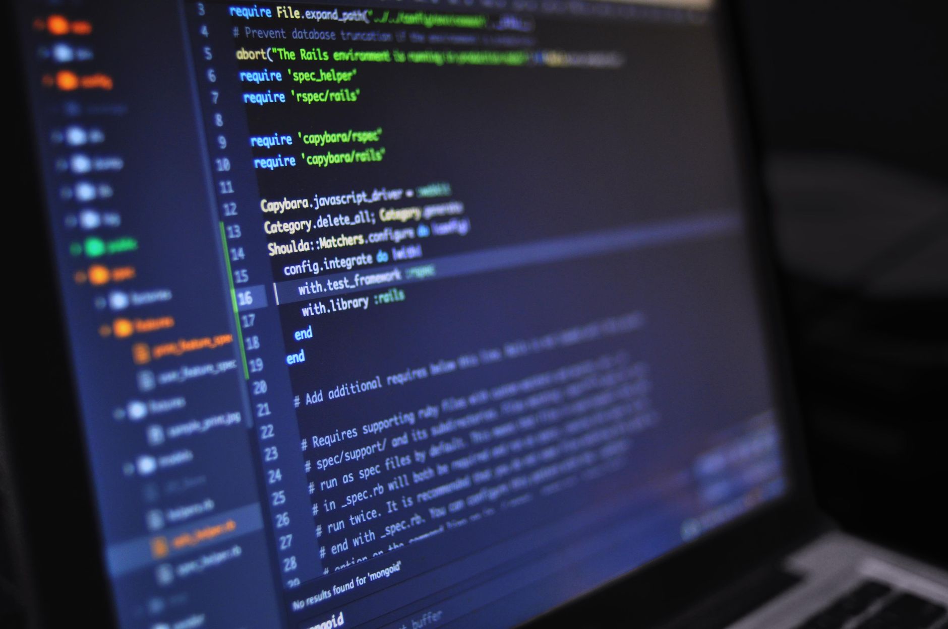 Laptop in a dark room displaying code, symbolizing silent credential-stealing malware